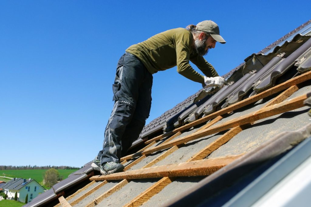 man installing roof tiles