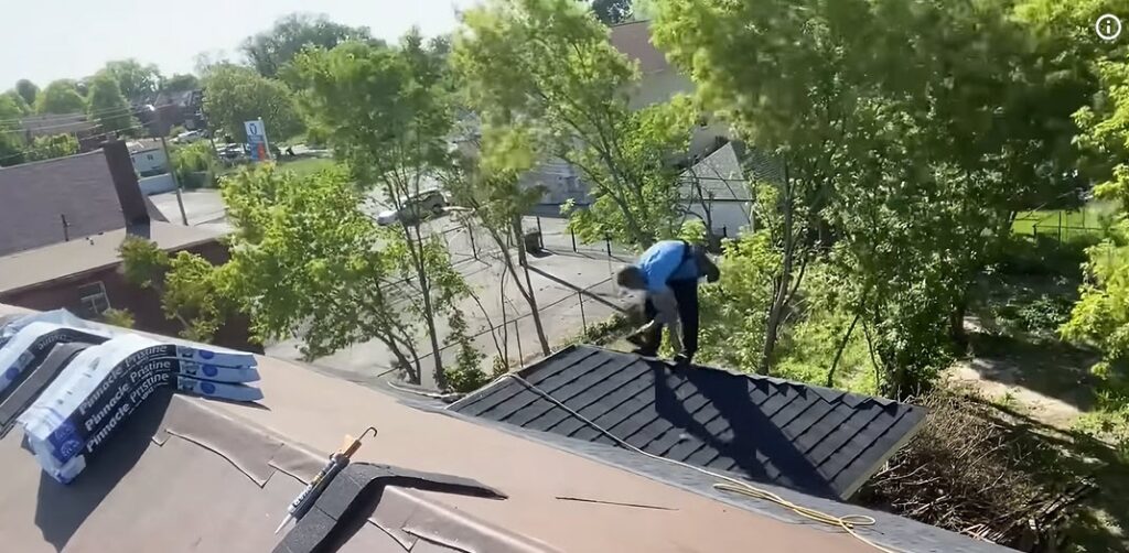 Aerial view of a roofer installing shingles on a residential roof in an Albuquerque, NM neighborhood